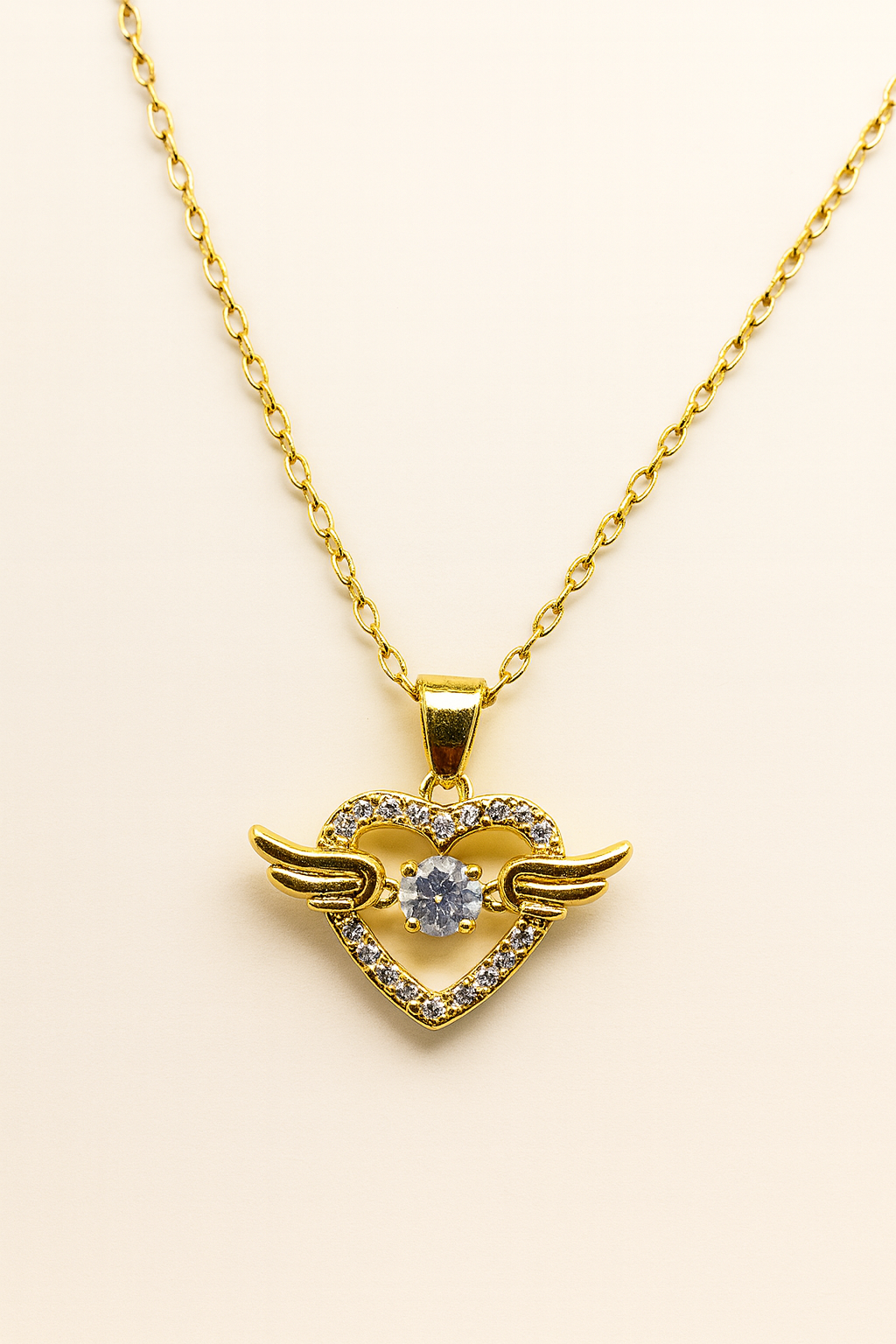 Collar dorado con colgante corazón alado